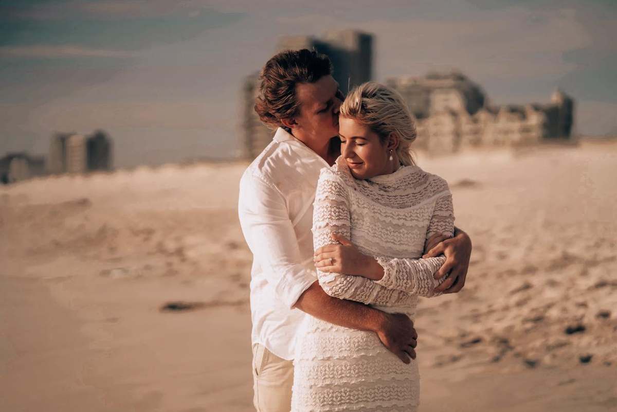 Stiaan en Carmen in 'n omhelsing op die strand